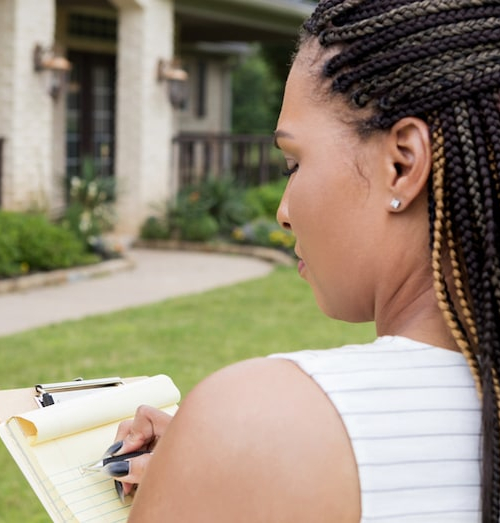 A woman appraising a home, indicating property assessment or valuation in real estate.