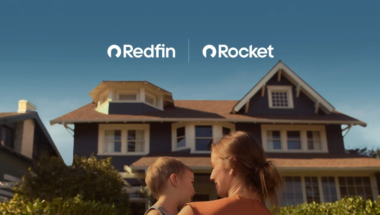 A mother holds a toddler on her hip while looking at the new house they bought with Redfin and Rocket Mortgage.