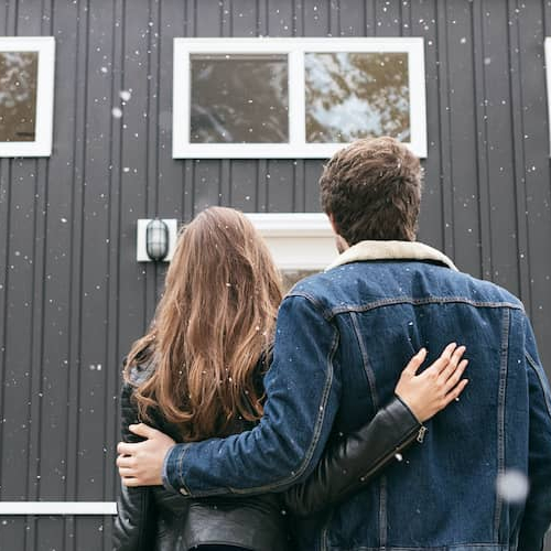 A couple looking towards a house possibly the one they just bought and thinking of starting a new chapter in it.