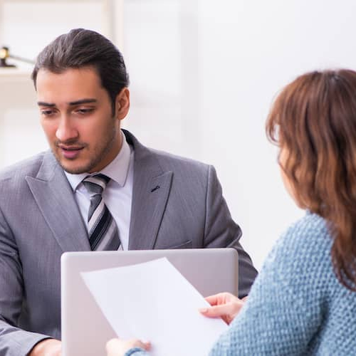 Two lawyers or real estate agents discussing some documents with a women.