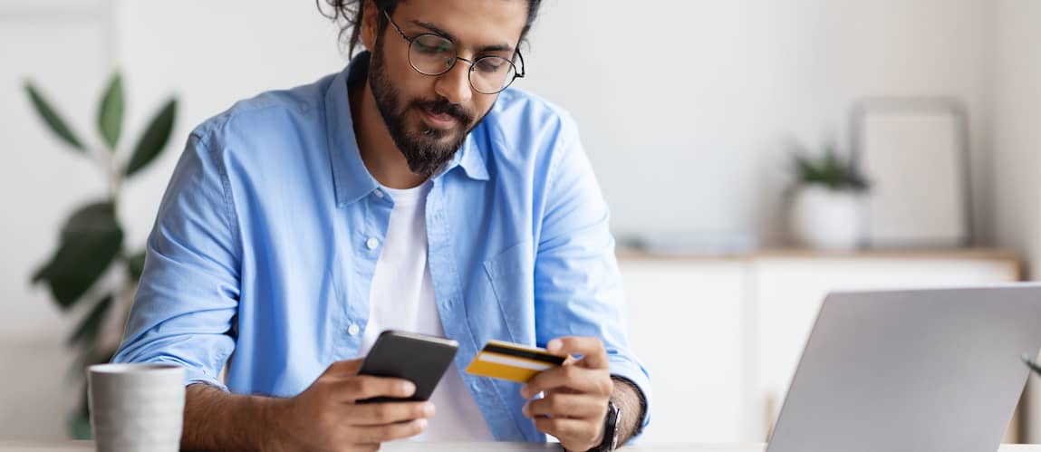 Man with ponytail paying for something on phone with his credit card.