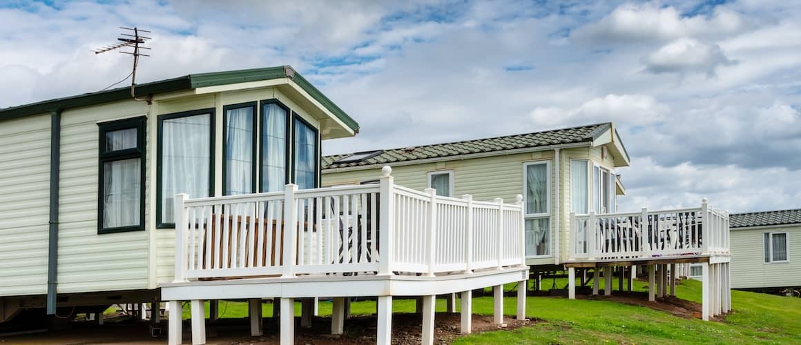 Two mobile homes with white decks.