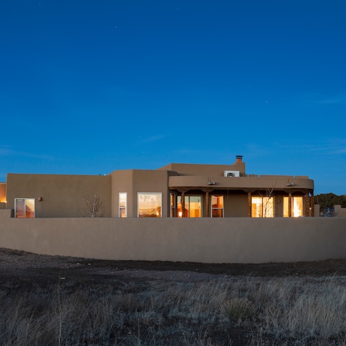Pueblo style home in Santa Fe, New Mexico at dusk.
