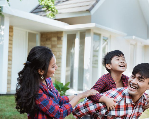 Image of family in front yard enjoying their home.