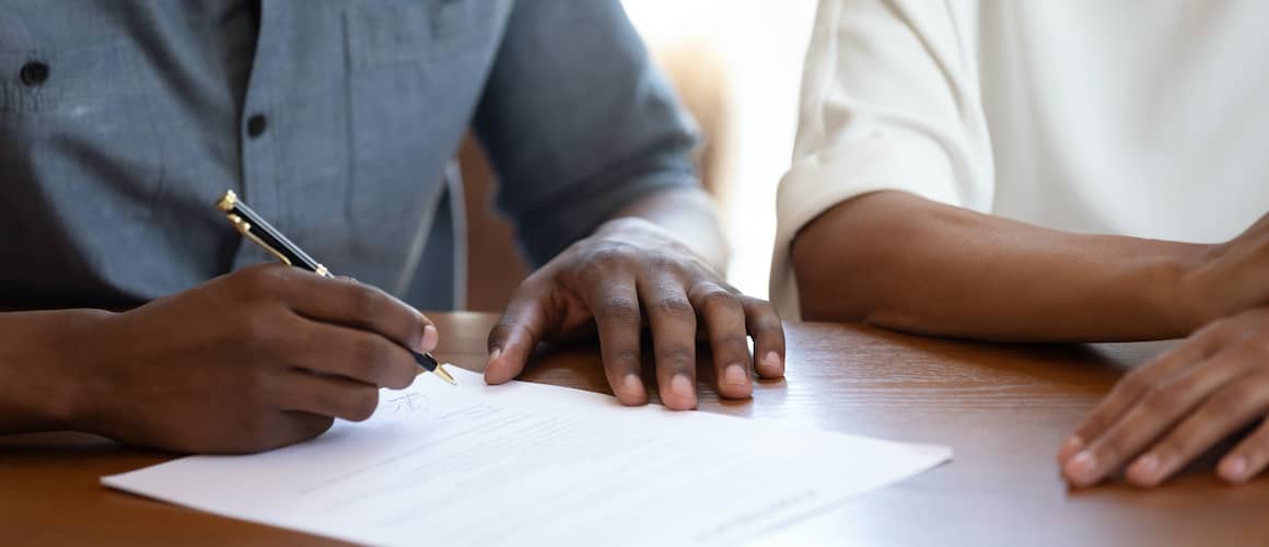 People signing a mortgage note or document.