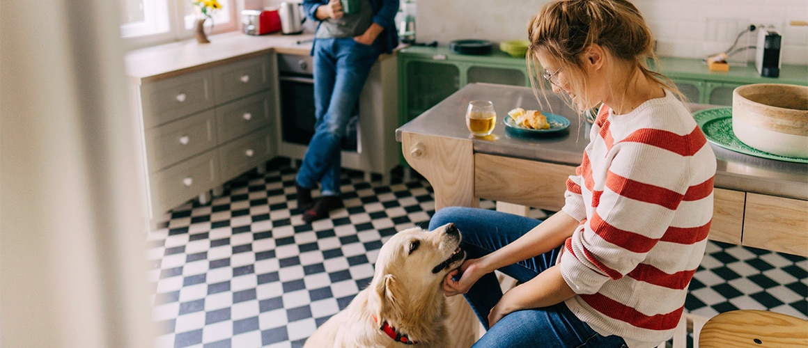 RHB Assets From IGX: A smiling woman with a golden retriever in a kitchen.