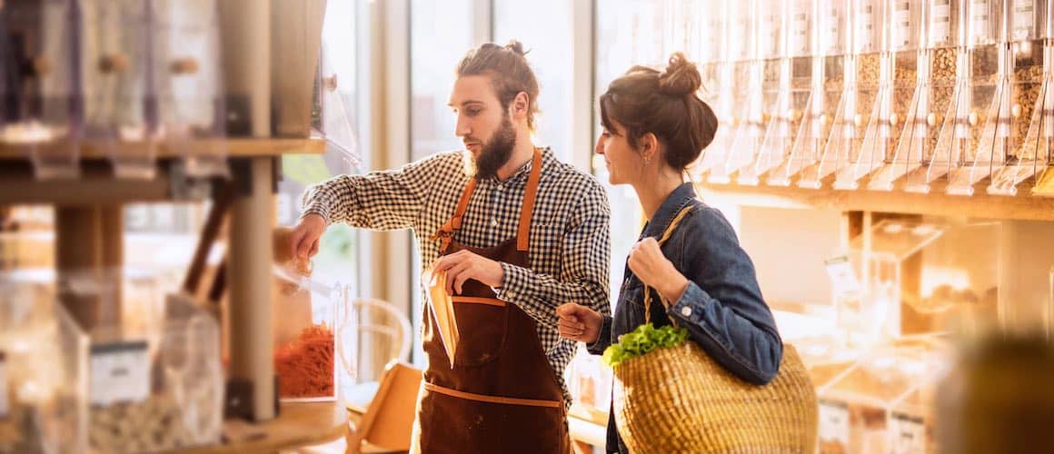 Image of small grocery owner helping client.