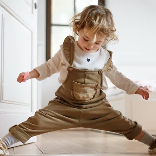 Toddler playing in doorway of home.