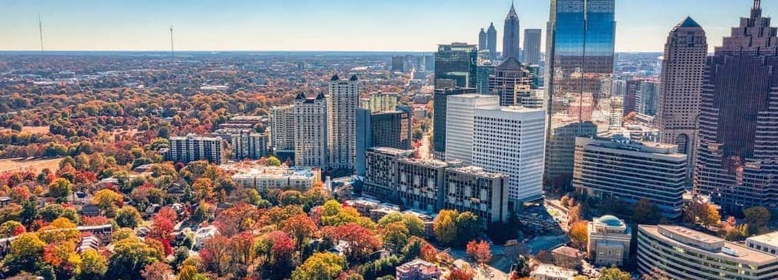 RHB Assets From IGX: Aerial view of Atlanta cityscape with skyscrapers and greenery