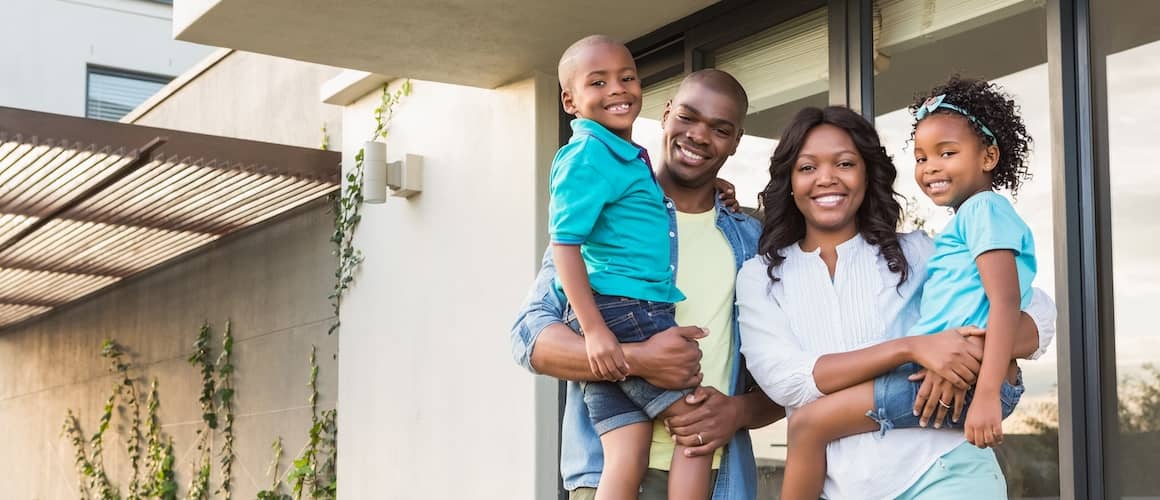 Black family of four outside of house