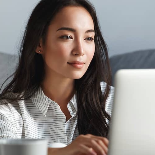 Woman reviwing information on her laptop.