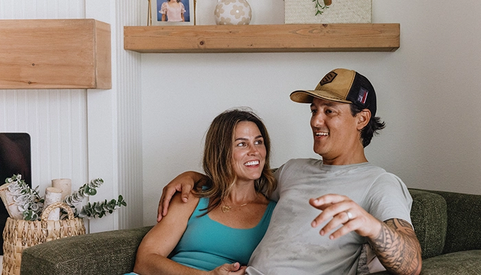 Couple sitting on large chair smiling and chatting.