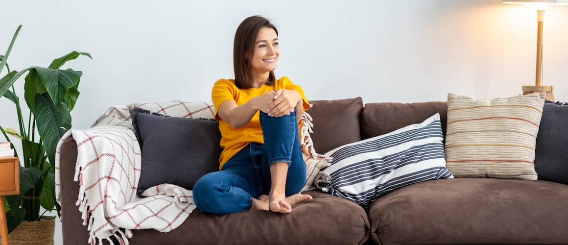 Happy couple on a couch looking at a phone