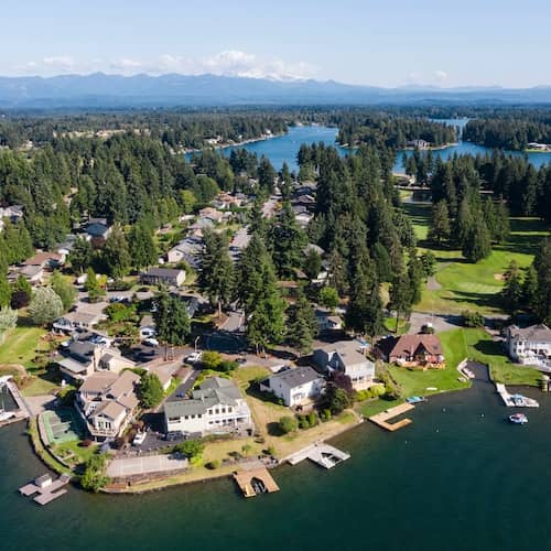 Homes on Lake Tapps waterfront surrounded by large Pine trees in Washington state.