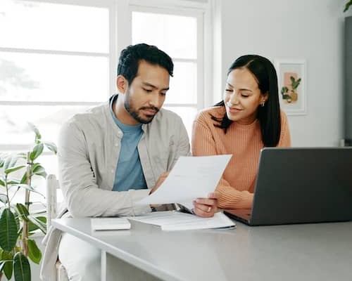 Couple reviewing documents at the kitchen table. 