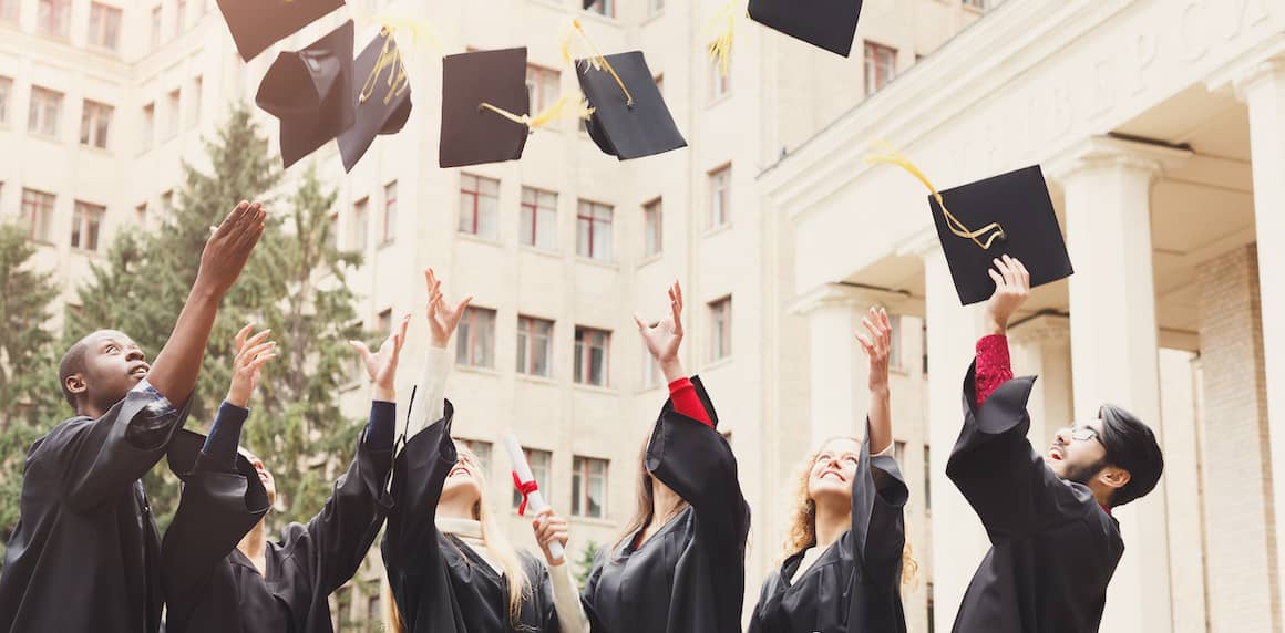 College students throwing graduation caps in the air.