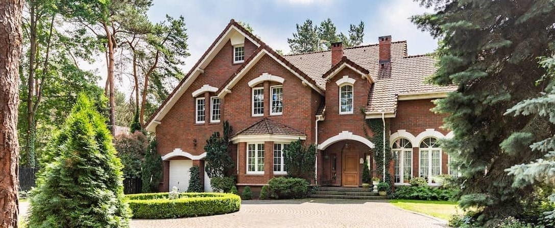 A large brick house surrounded by trees.