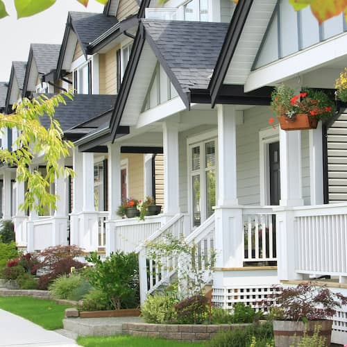 White condos with small porches, depicting a residential complex or condominiums.