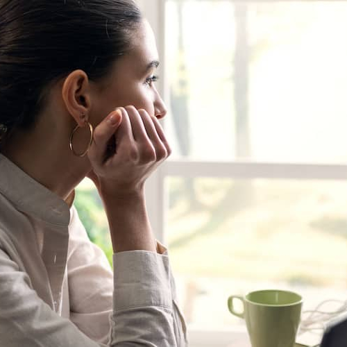 An image showing a woman engrossed in her thoughts possibly related to some real estate investment or work.