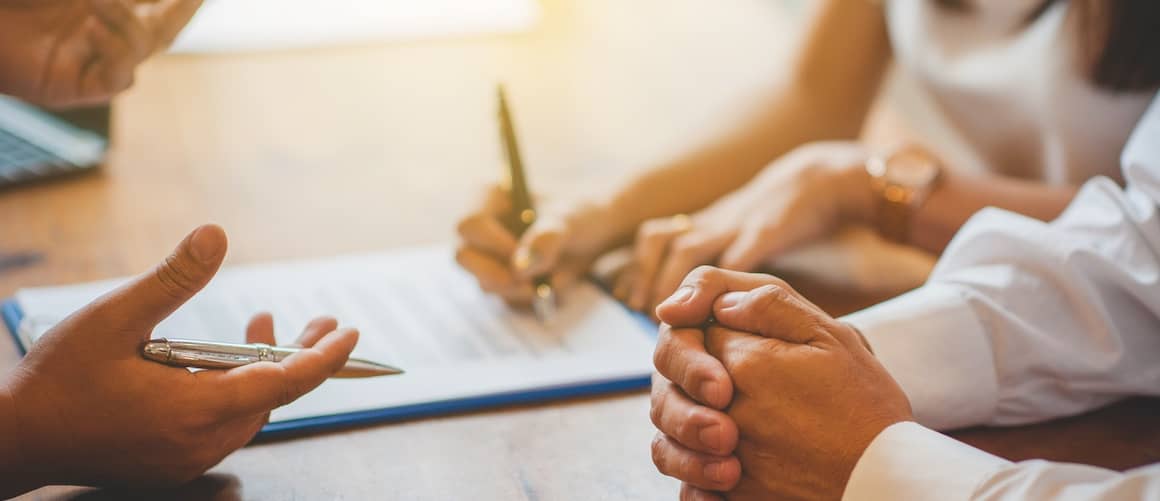 Woman signing loan paperwork.