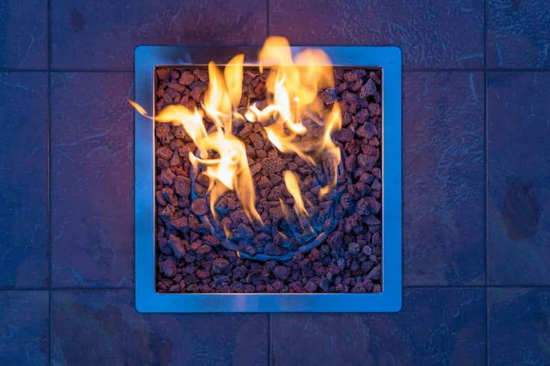 RHB Assets From IGX: Modern square fire pit surrounded by outdoor seating in a backyard.