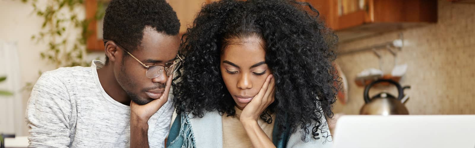 A couple reviewing escrow documents, possibly related to a real estate transaction or property purchase.