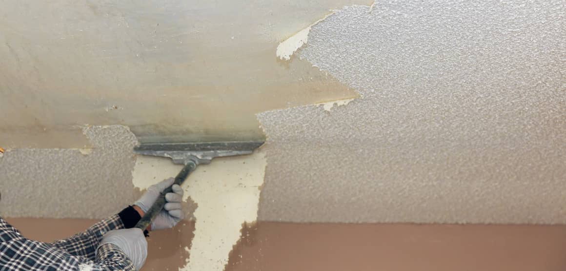 RHB Assets From IGX: Person scraping popcorn ceiling texture off with a putty knife.