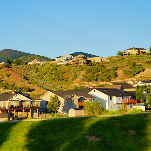 Several houses on the grassy hills of Pocatello, Idaho.