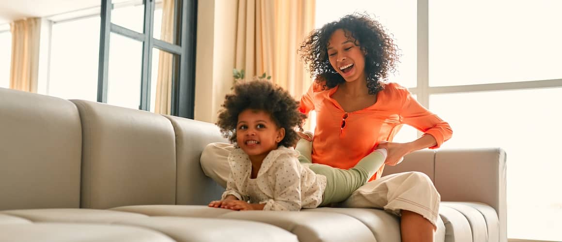 Happy mother and baby together on a couch.