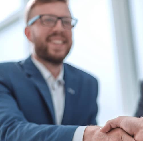 Smiling businessmen shaking hands, symbolizing a successful business deal or partnership.