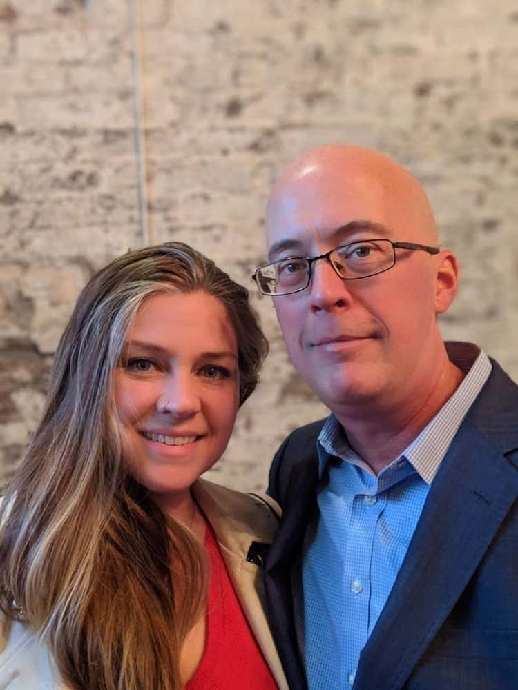 Man and woman smiling standing close together.