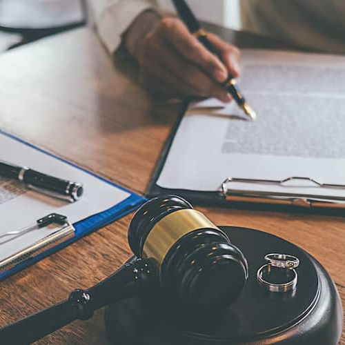 A couple signing divorce papers, suggesting a legal process related to property or asset division.