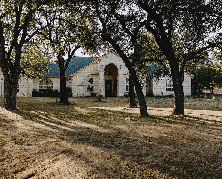 Large home with a front yard and trees