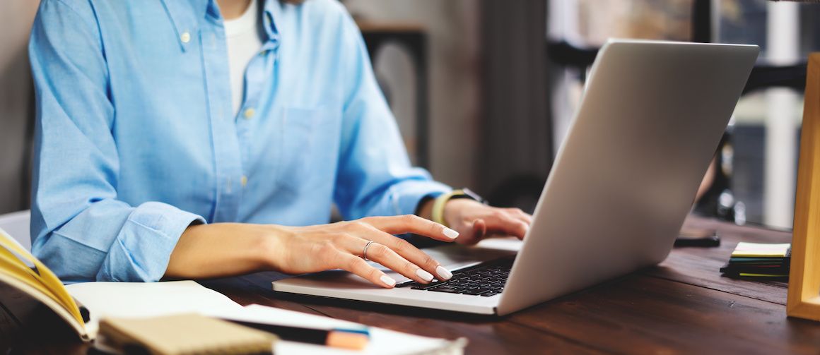 A woman working on a computer at home, potentially related to online mortgage or real estate activities.