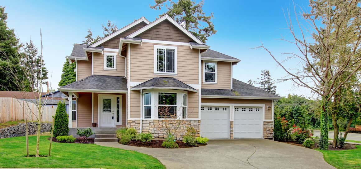 RHB Assets From IGX: Tan-colored suburban home with a well-manicured lawn and street view.