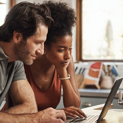 Couple doing financial planning on a laptop, indicating financial management or budgeting.