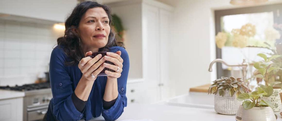 RHB Assets From IGX: Middle-aged woman holding a coffee cup while smiling outdoors