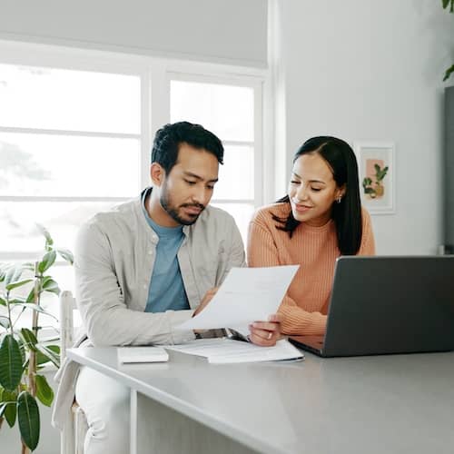 Couple reviewing documents at the kitchen table. 