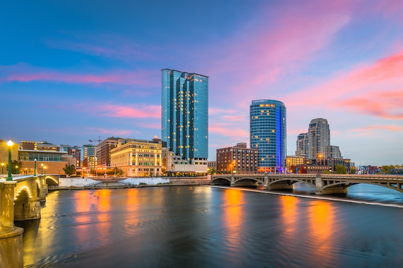 Grand Rapids skyline near river at sunset.