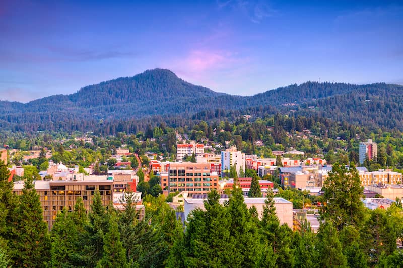 RHB Assets From IGX: Picturesque Eugene, Oregon, with a river, bridge, and lush greenery.