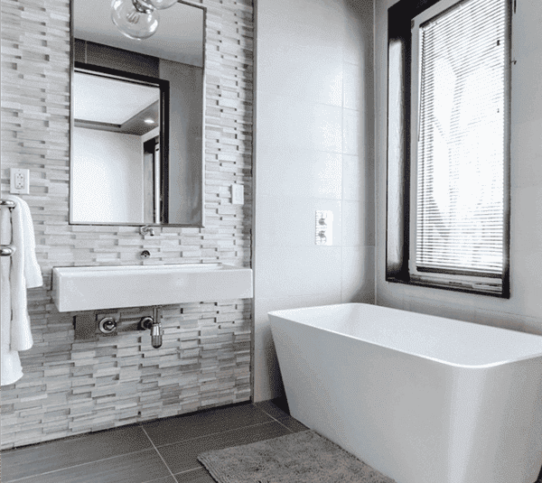 A clean modern designed bathroom with white and grey tiles.