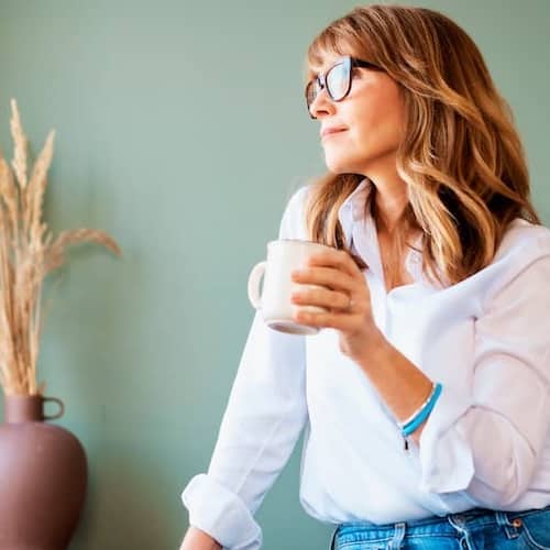 A woman enjoying a cup of coffee while thinking about something.