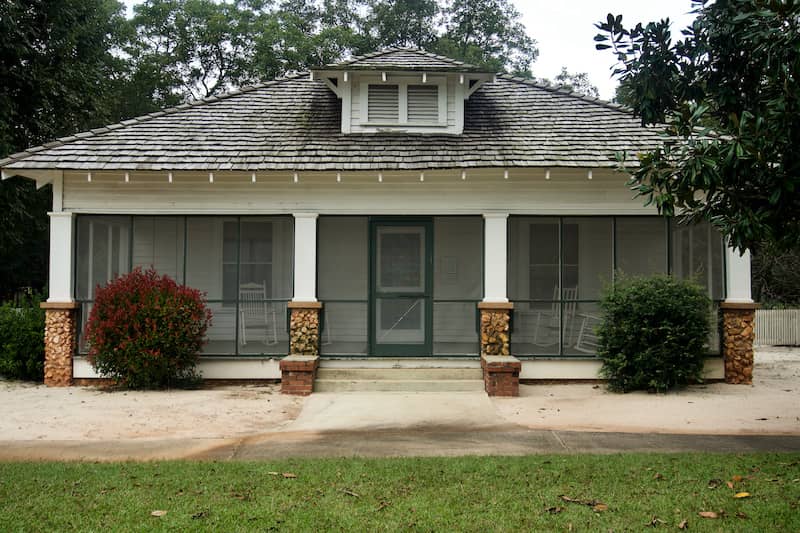 RHB Assets From IGX: Screened front porch with comfortable furniture and potted plants.