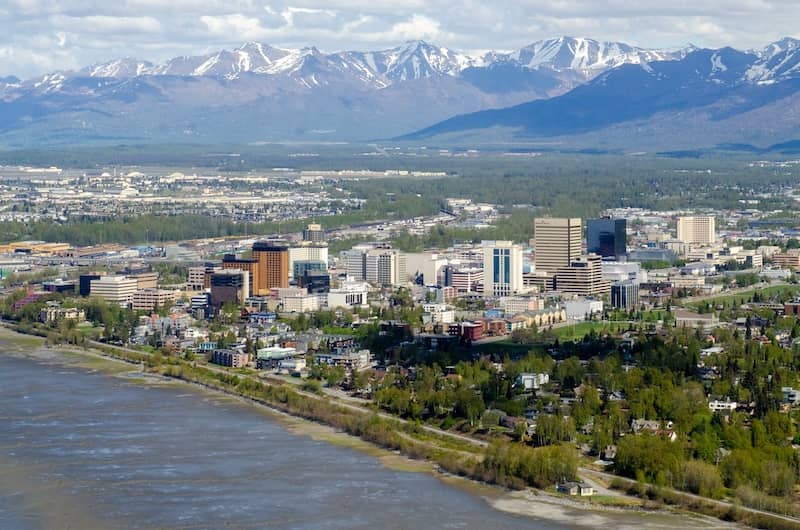 A view of downtown Anchorage, Alaska with snowcapped mountains in the distance.