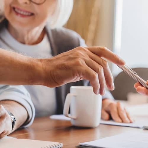 Older couple signing a home contract, potentially finalizing a property transaction.