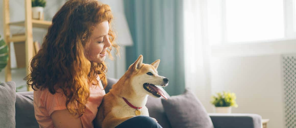 Young woman with a dog, indicating a lifestyle with pets or outdoor activities.