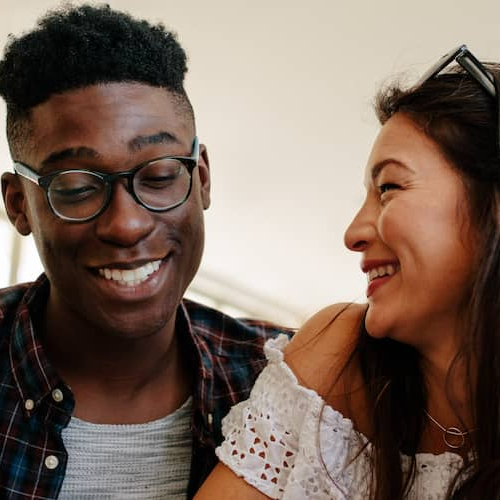 Happy couple looking at a contract, potentially finalizing a deal or agreement related to real estate.