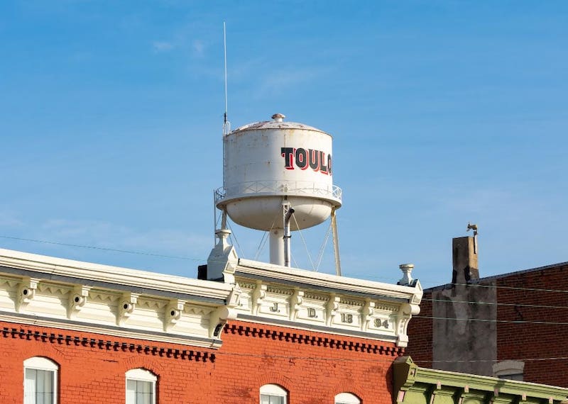 A water tower over a historic brick building in Toulon.