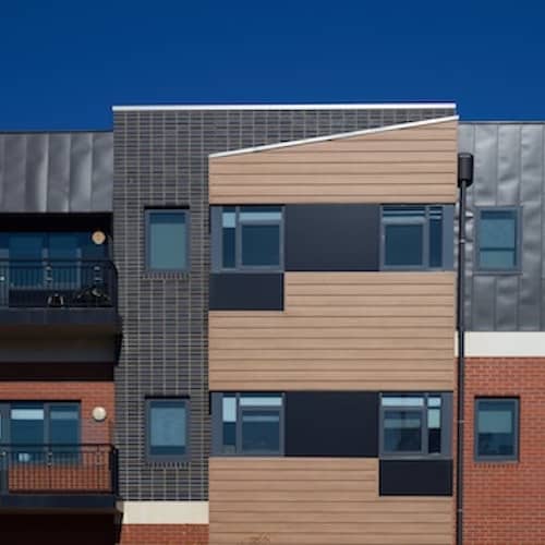 Modern apartment building with abstract style facade and in earth tones.