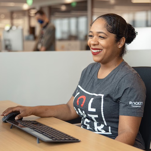 Woman at computer in open office.